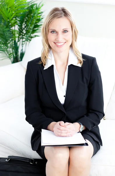 Confiante loira empresária sorrindo para a câmera sentada em um — Fotografia de Stock