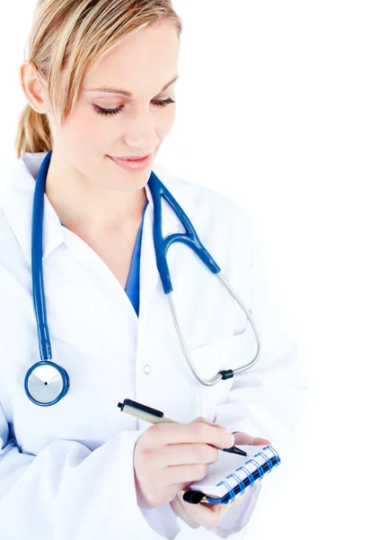 Konzentrierte Ärztin macht sich Notizen auf ihrem Notizblock — Stockfoto