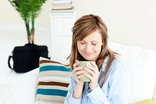 Uvolněné podnikatelka užívat kávu sedět na pohovce — Stock fotografie