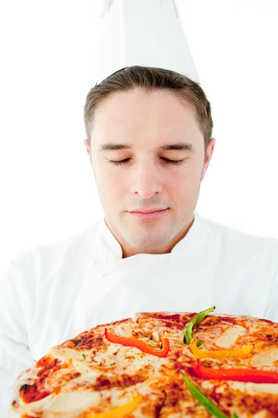 Jovem cozinheiro masculino cheiro em pizza com olhos fechados — Fotografia de Stock