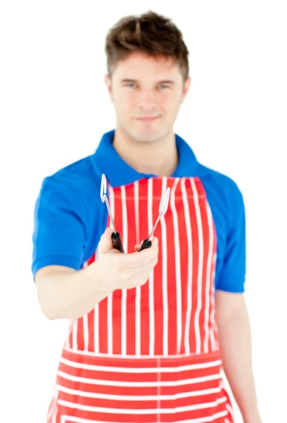 Bonito jovem cozinheiro segurando um utensílios de cozinha — Fotografia de Stock