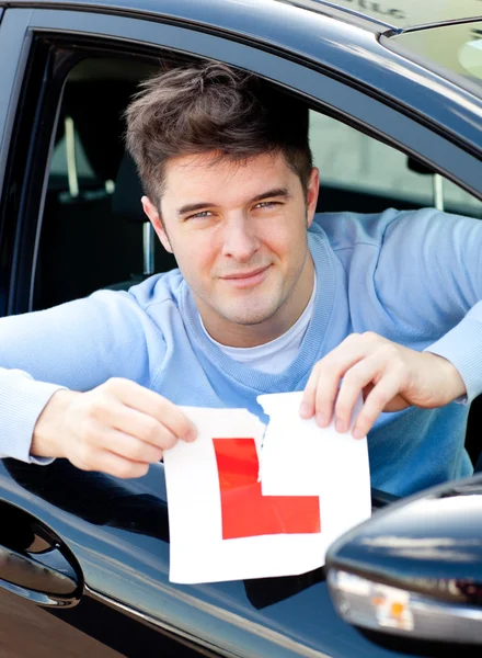 Happy young male driver tearing up his L sign — Stock Photo, Image