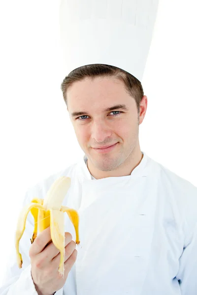 Charmoso cozinheiro masculino segurando banana sorrindo para a câmera — Fotografia de Stock