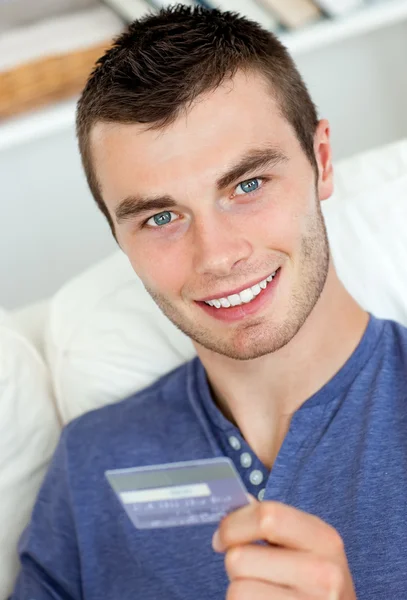 Joyful man holding a card smiling at the camera — Stock Photo, Image