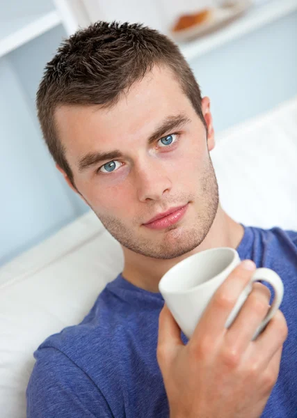 Portrait of a serious young man looking at the camera holding a — Stock Photo, Image