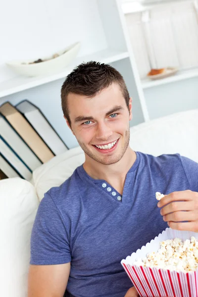 Śmiech kaukaski mężczyzna jedzenie popcornu patrząc na kamery — Zdjęcie stockowe