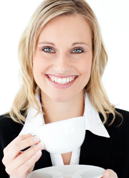 Merry businesswoman holding a cup smiling at the camera — Stock Photo, Image