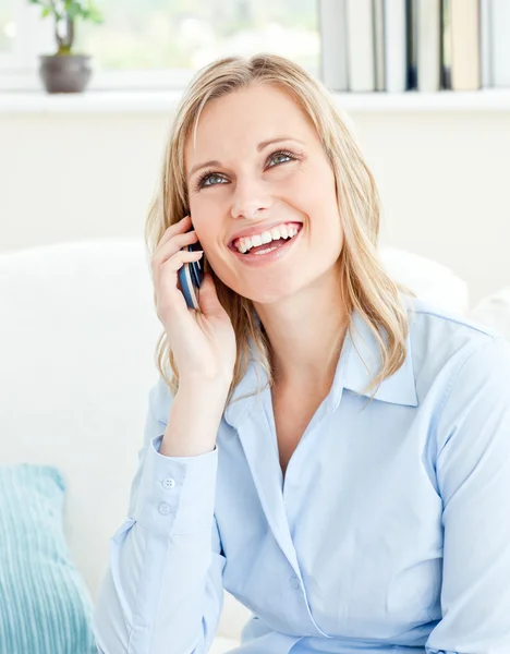Vrolijke zakenvrouw praten over telefoon zittend op een bank — Stockfoto