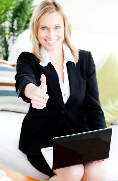 Postive businesswoman with thumb up using her laptop — Stock Photo, Image