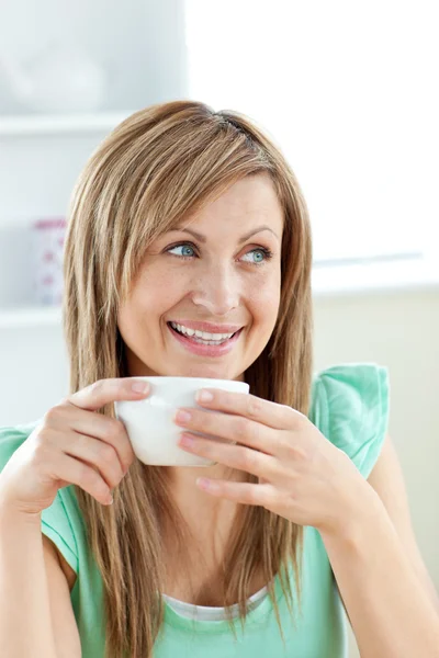 Mulher caucasiana encantadora segurando uma xícara de café sentado no — Fotografia de Stock