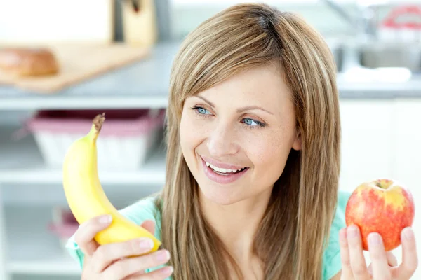Positive caucasian woman holing a bananan and an apple — Stock Photo, Image