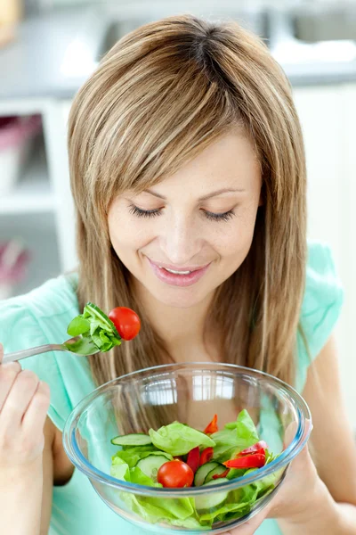Mignon jeune femme manger une salade saine dans la cuisine — Photo