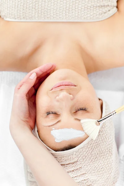 Relaxado jovem mulher receber creme branco em seu rosto — Fotografia de Stock