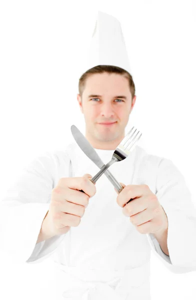 Pewnie kucharz mężczyzna trzyma widelec i nóż, uśmiechając się do kamery — Zdjęcie stockowe