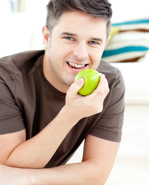Uśmiechnięty kaukaski mężczyzna trzyma jabłko patrząc na kamery — Zdjęcie stockowe