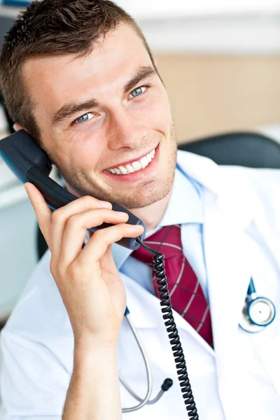 Porträtt av en attraktiv läkare pratar på telefon leende på den — Stockfoto