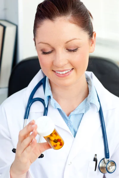 Lächelnde Ärztin mit Tabletten in ihrem Büro — Stockfoto