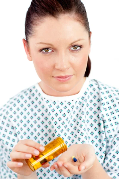 Удручённая больная женщина держит таблетки, глядя в камеру. — стоковое фото