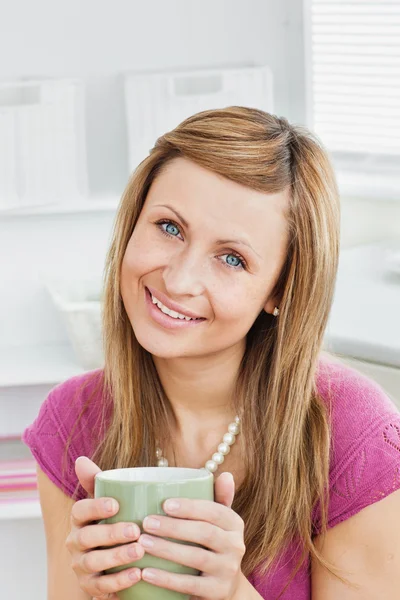Portrait of a captivating woman holding a cup smiling at the cam — Stock Photo, Image