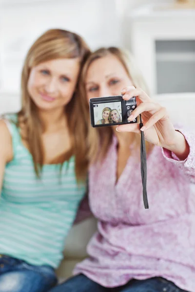 Nära kvinnliga vänner som tar bilder av sig själva med en digital kamera — Stockfoto
