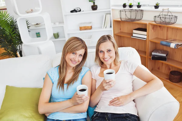 轻松两个女人喝咖啡在对照相机微笑 — 图库照片