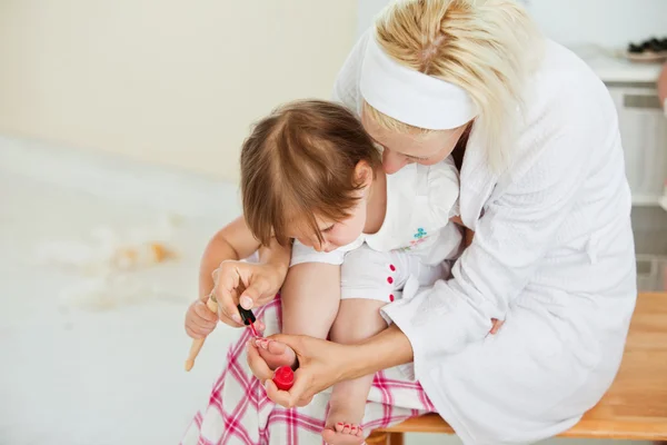 Geconcentreerde moeder haar dochtertje nagels maken — Stockfoto