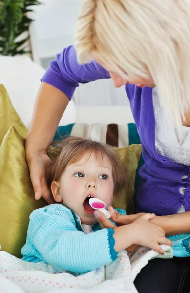 Chory dziewczynka się syrop z jej opieki matki — Zdjęcie stockowe