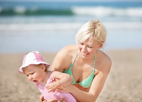 Lächelnde Mutter am Strand mit ihrer Tochter — Stockfoto