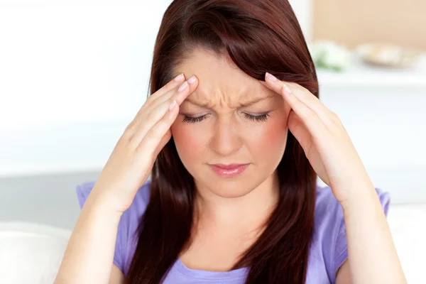 Młoda kobieta z bólem głowy w domu — Zdjęcie stockowe