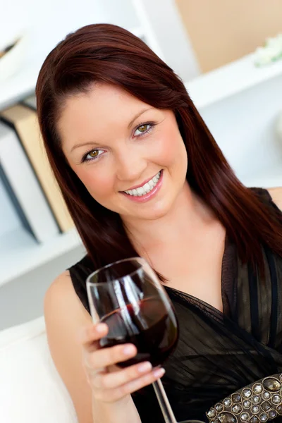 Elegante giovane donna che tiene un bicchiere di vino a casa — Foto Stock