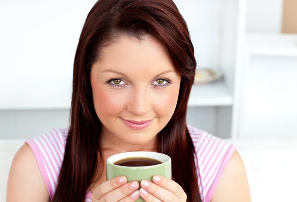 Retrato de uma mulher atraente segurando uma xícara de café em casa — Fotografia de Stock
