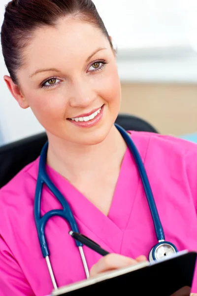 Charming female nurse holding a clipboard — Stock Photo, Image
