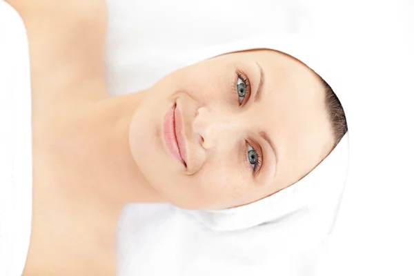 Portrait of a cute young woman lying on a massage smiling at the — Stock Photo, Image