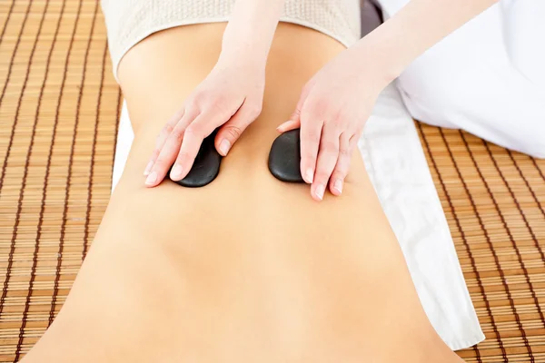Close-up de uma mulher caucasiana recebendo uma massagem nas costas com quente — Fotografia de Stock