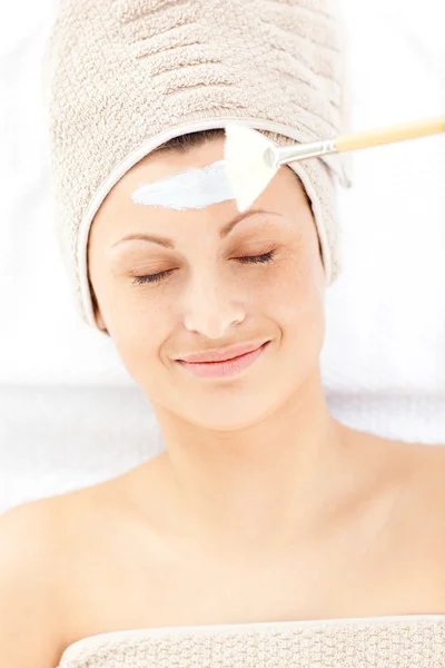 Glücklich entspannte Frau erhält weiße Creme auf ihrem Gesicht — Stockfoto
