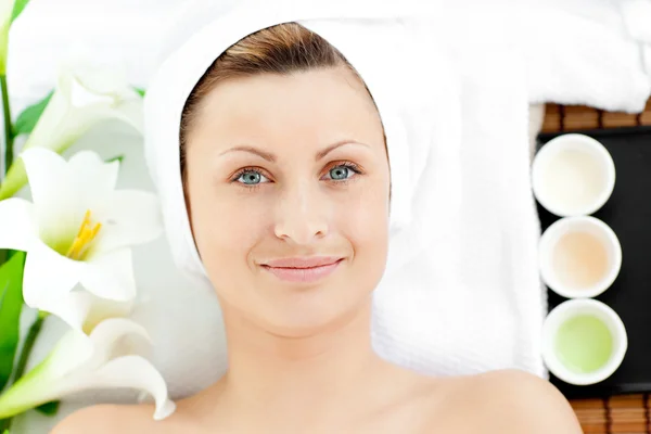 Smiling young woman lying on a massage table looking at the came — Stock Photo, Image