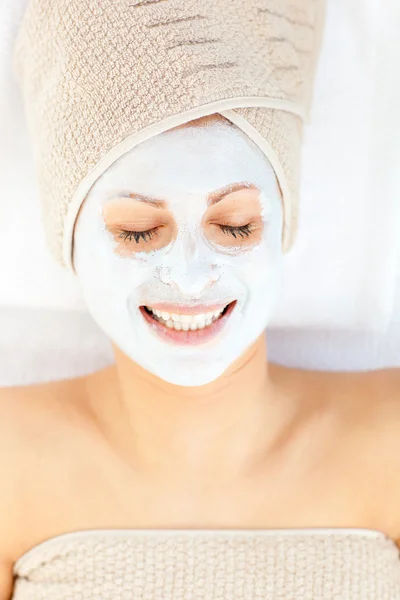 Giovane donna allegra con crema bianca sul viso rilassante su un mas — Foto Stock