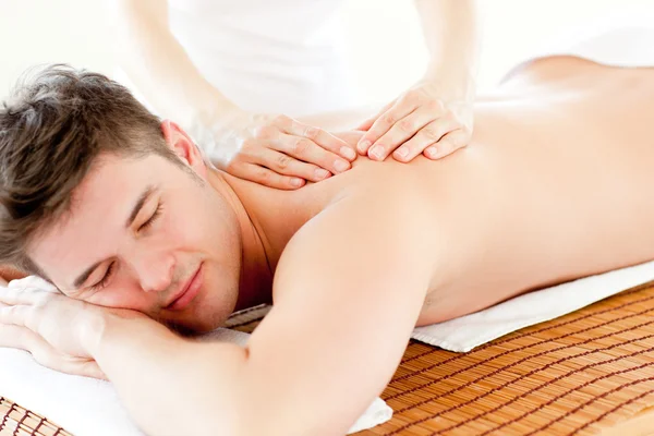 Харизматичный расслабленный мужчина наслаждается массажем спины в спа-центре — стоковое фото
