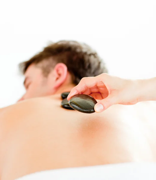 Detail pozitivní mladý muž s masáž zad s horkou — Stock fotografie