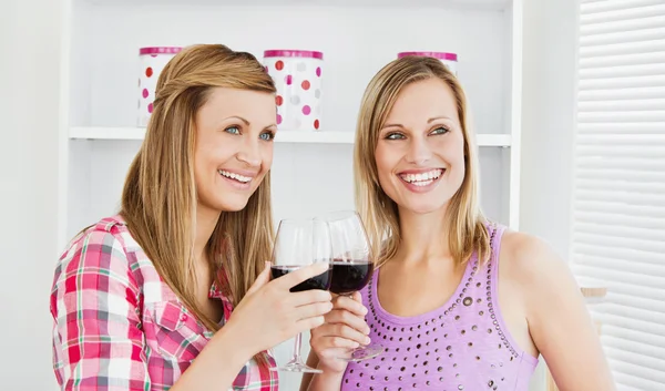 Animerade kvinnliga vänner dricker vin i köket — Stockfoto