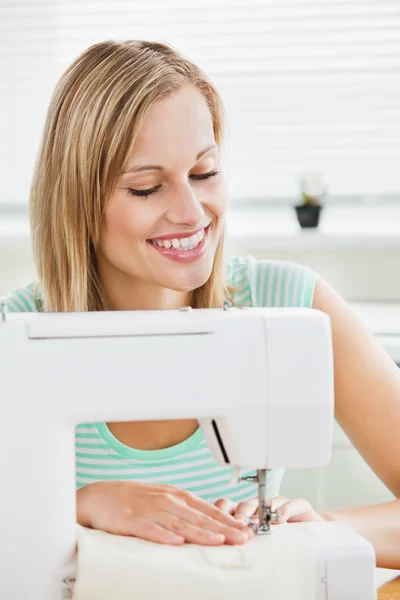 Portrait of a smiling woman sewing clothes at home — Stock Photo, Image