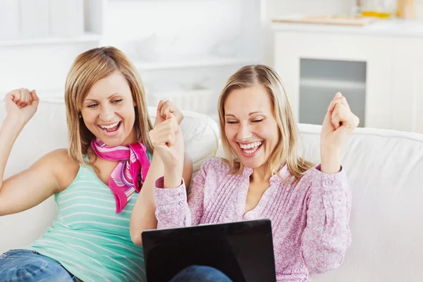 Entusiastiska vänner med armar upp tittar på den bärbara datorn — Stockfoto