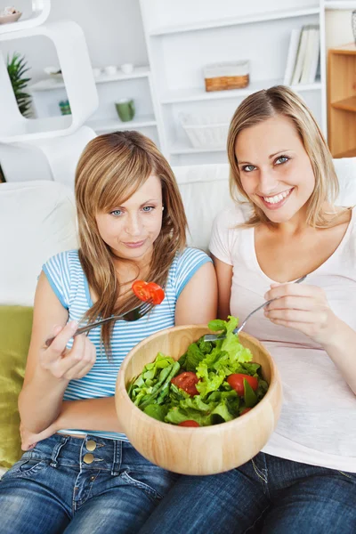 Donne affamate che mangiano un'insalata in salotto — Foto Stock