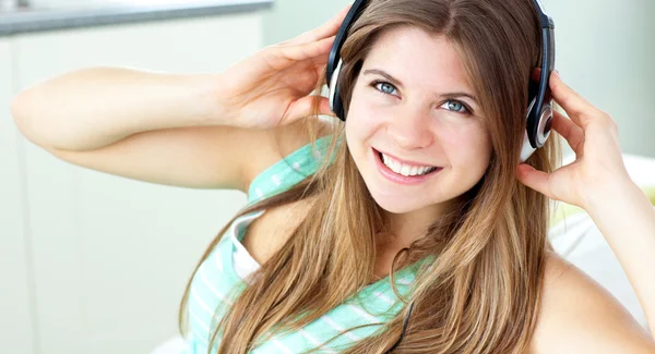 Une jeune femme souriante écoute de la musique — Photo