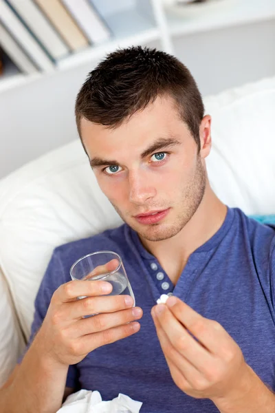 Deseased young man taking pills at home — Stock Photo, Image