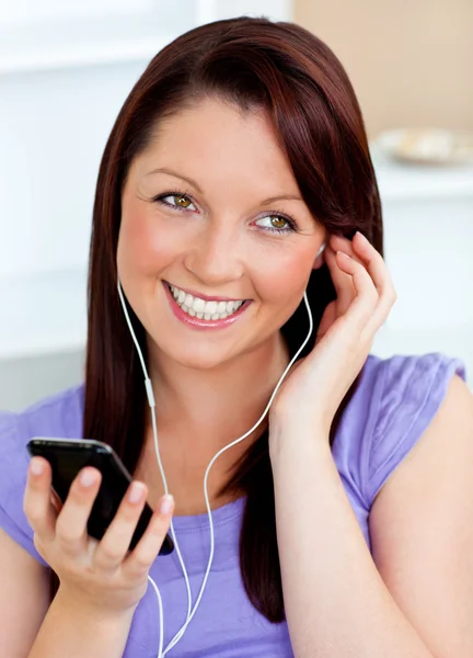 Mujer feliz usando su teléfono celular para escuchar música con auriculares —  Fotos de Stock