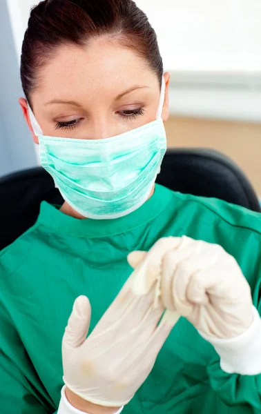 Beautiful female doctor with scrubs getting off her gloves — Stock Photo, Image