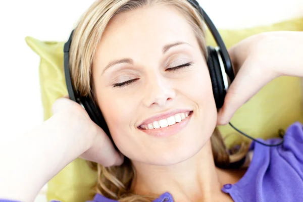 Donna deliziata che ascolta musica in salotto — Foto Stock