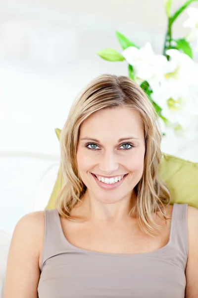 Portrait of a happy woman sitting on the sofa — Stockfoto