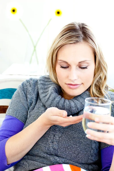 Mulher doente tomando pílulas segurando um copo de água — Fotografia de Stock